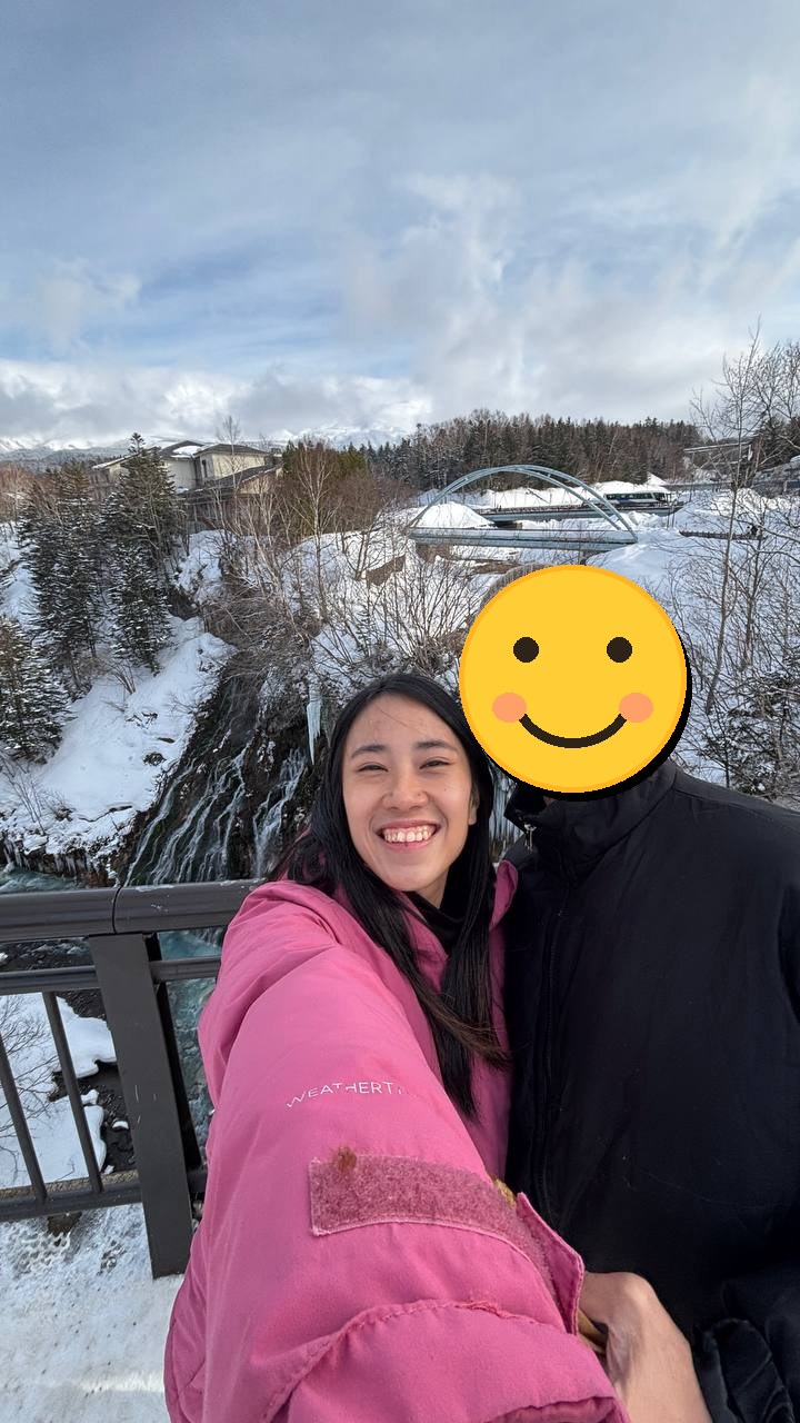 Vicki smiling outdoors with her partner